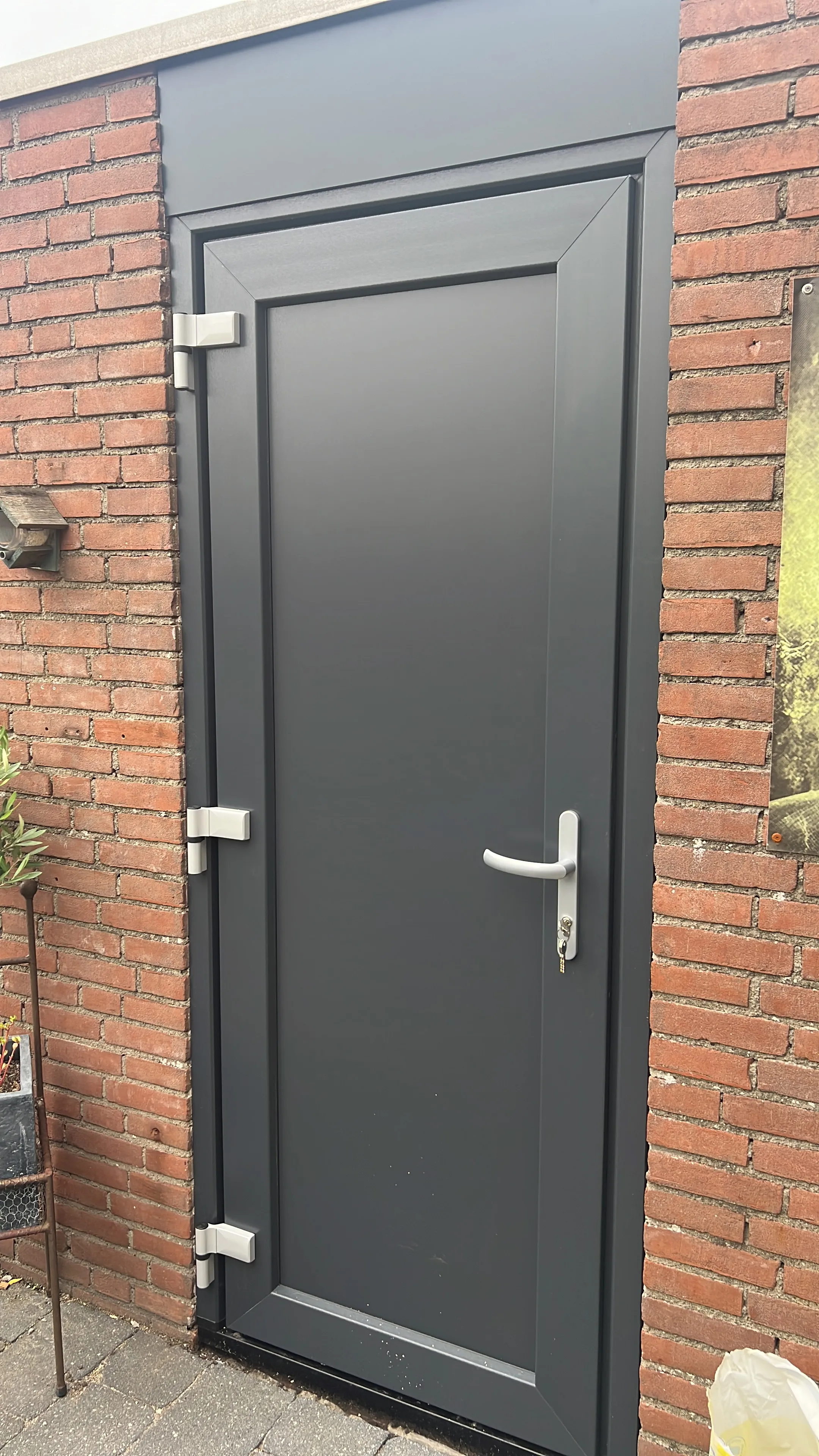 Donkere achterdeur op maat in een bestaande bakstenen gevel