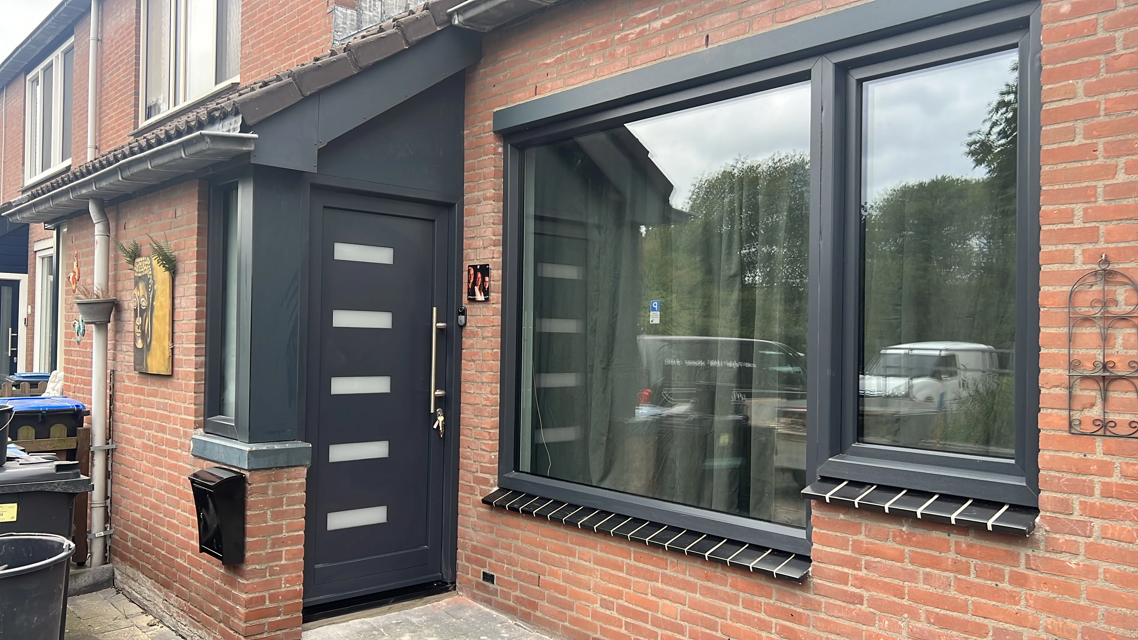 Donkere kozijnen en voordeur in een bakstenen voorgevel